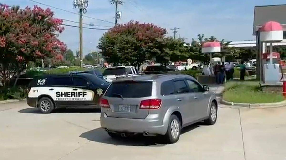 Law enforcement agencies surround an area around a gas station in Clemmons, NC, on Friday, Aug. 5, 2022. Charlotte-Mecklenburg Police were a part of a multi-agency effort that left a murder suspect fatally shot and a law enforcement officer injured.