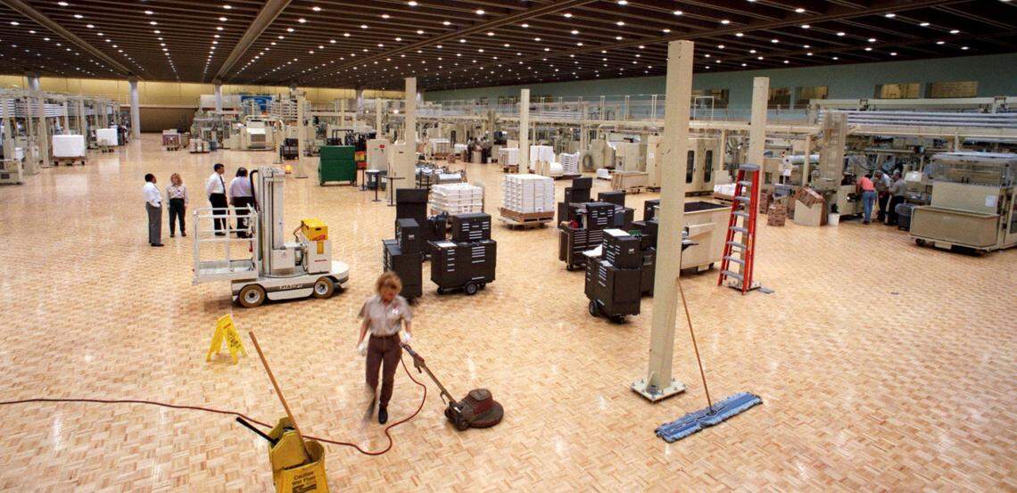 In this 1996 file photo, a Philip Morris worker buffs the hardwood parquet floor in the massive cigarette manufacturing plant in Concord.