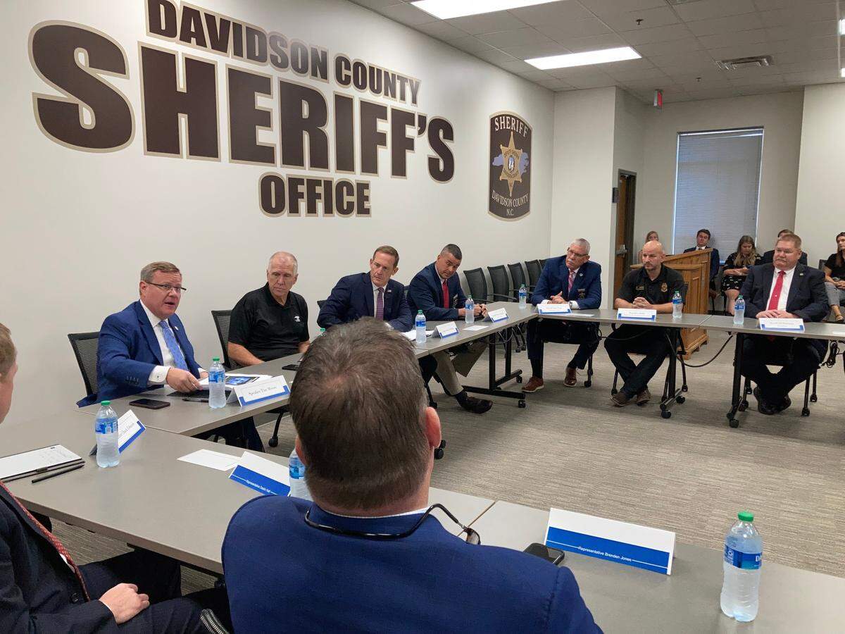 Along the back wall, Speaker Tim Moore, left, Sen. Thom Tillis and Rep. Ted Budd talk about immigration during a roundtable in Lexington on Wednesday.