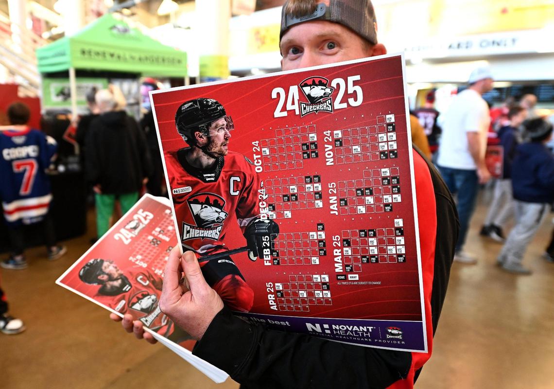 Charlotte Checkers ice crew member David Goudreau hands out the team’s season calendar to fans as they enter Bojangles Coliseum in Charlotte, NC on Friday, October 18, 2024. The Charlotte Checkers hosted the Cleveland Monsters in the home opener.