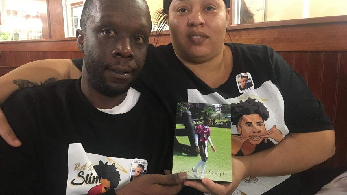 Lacosta Doby, left, and Tawana Shannon hold a plaque honoring their son, DaQuan Shannon. DaQuan was shot and killed in March outside a QuikTrip convenience store in Charlotte.