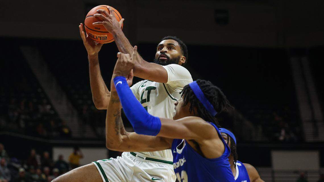 UNC Charlotte’s Brice Williams, left, shoots over Middle Tennessee’s defense during the game at Dale F. Halton Arena on Thursday, December 29, 2022. Charlotte defeated Middle Tennessee, 82-67.