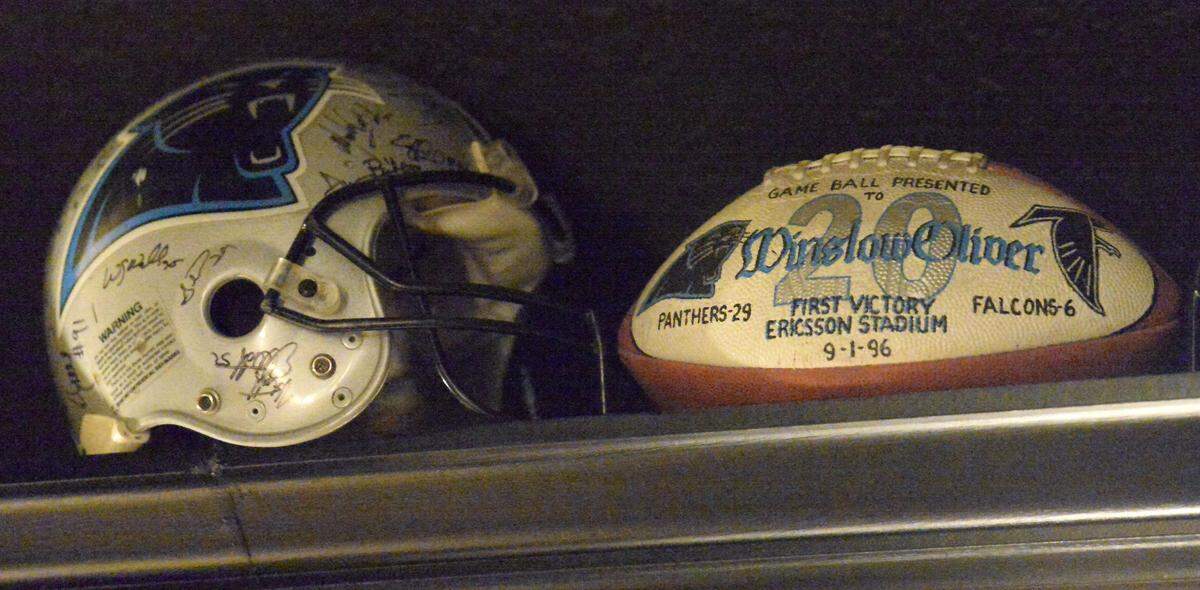 Souvenirs from Winslow Oliver’s career with the Carolina Panthers -- including a signed helmet and a game ball commemorating the team’s first win at what is now known as Bank of America Stadium -- line one wall of a room at his home in Richmond, Texas.