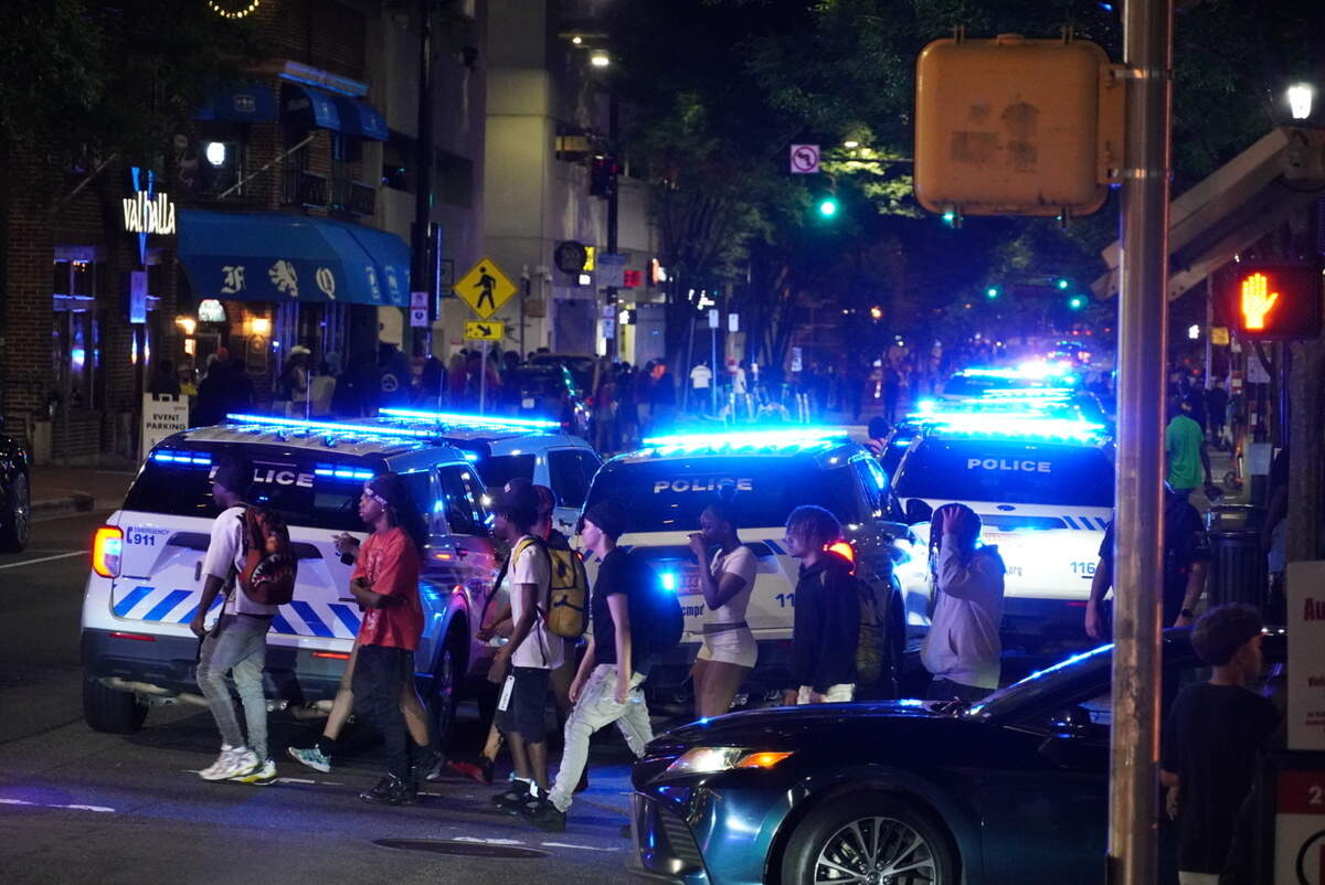 CMPD police cruisers lined the sidewalk of South Church Street after police closed Romare Bearden Park on Saturday to enforce curfew.