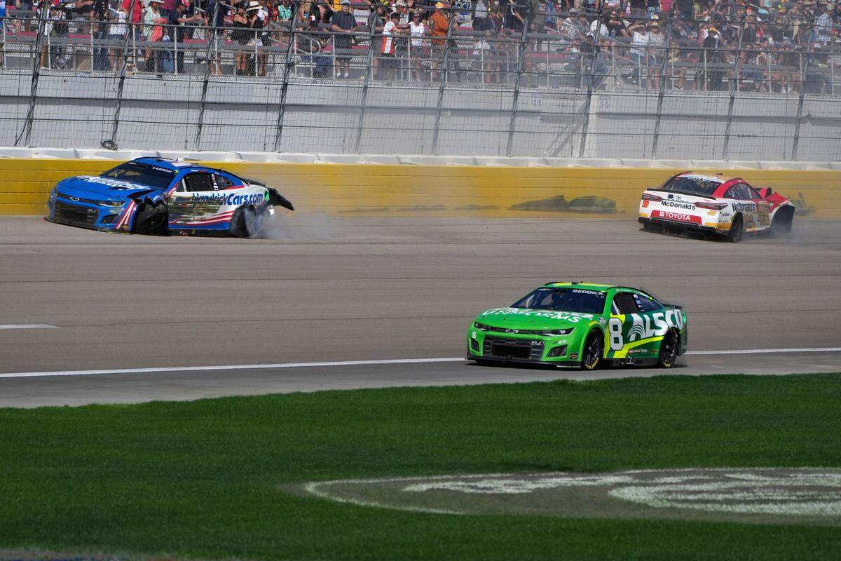 Kyle Larson, left, and Bubba Wallace, right, crash during a NASCAR Cup Series auto race Sunday, Oct. 16, 2022, in Las Vegas. (AP Photo/John Locher)