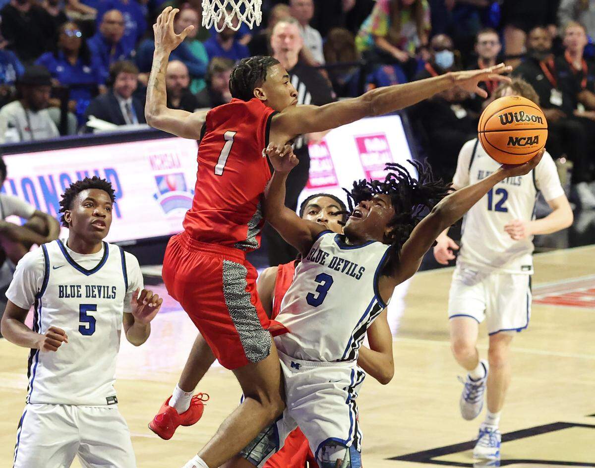 Mooresville’s Jordan Walton, right, tries to avoid the block of Durham Southern’s Jakari Glaspie, left, during action in the NCHSAA 7A boys championship game on Saturday, March 14, 2026 at Lawrence Joel Veterans Memorial Coliseum in Winston-Salem, NC.
