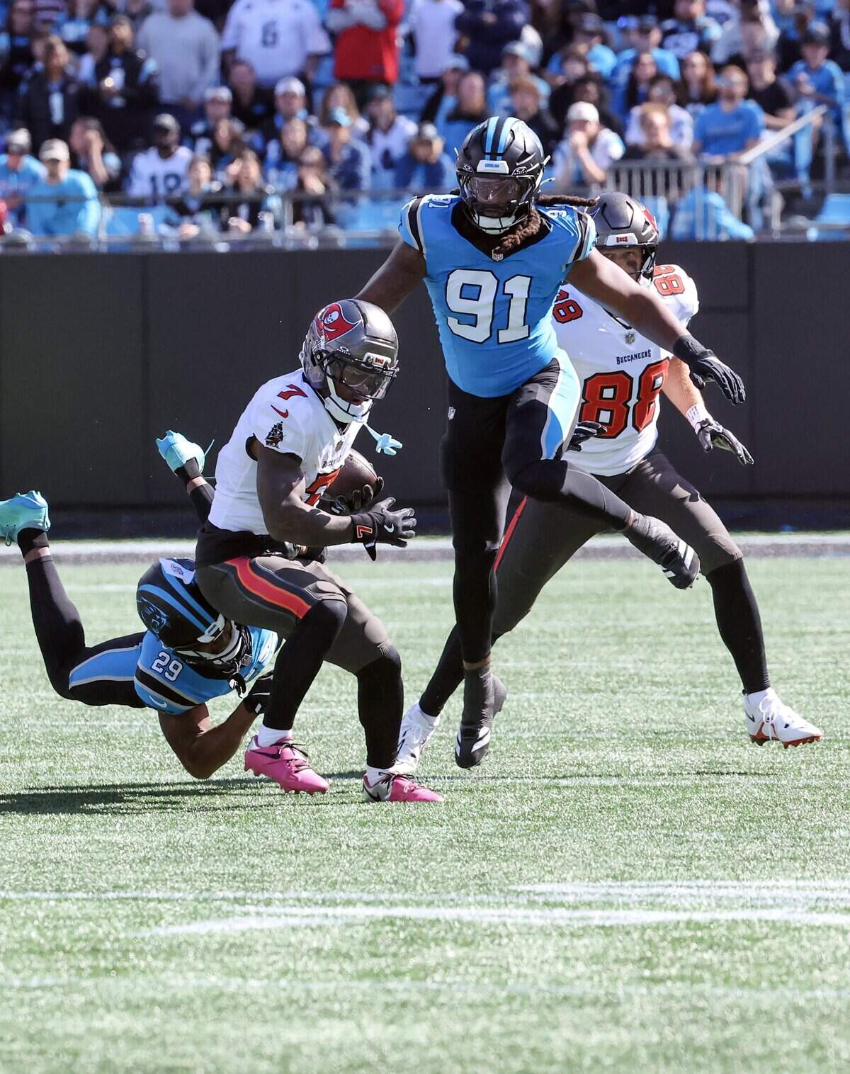 Tampa Bay Buccaneers running back Bucky Irving carries the ball as Carolina Panthers cornerback Akayleb Evans, left, and offensive lineman Pat Jones II try to stop him on Sunday, Oct. 25, 2026 at Bank of America Stadium in Charlotte.