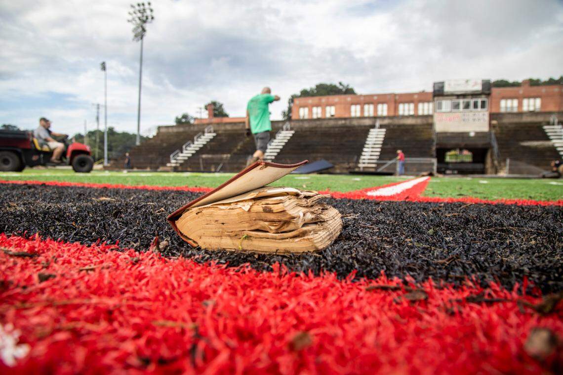 A waterlogged bible sits at the 50 yard line of the Pisgah High School football field in Canton after remnants from Tropical Storm Fred caused flooding in parts of Western North Carolina Tuesday. Search and rescue teams continue to search the area as 20 people are missing and 2 people were found dead.