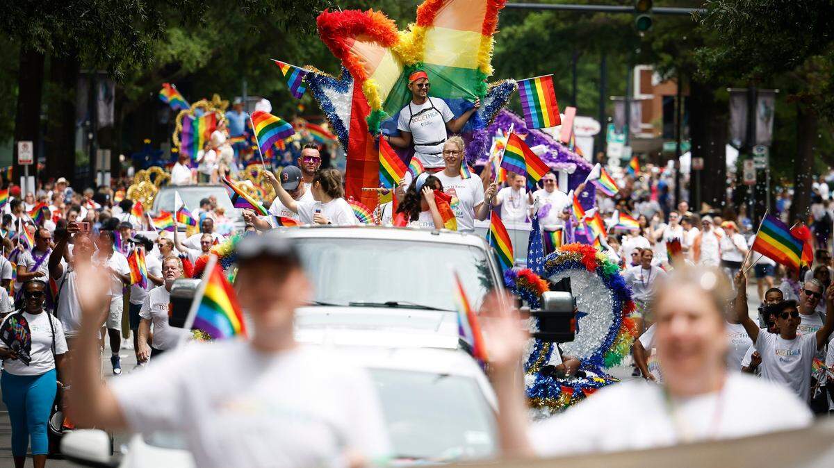 Parade participants wave at the crowd as they move through Uptown during the Charlotte Pride Parade, Sunday, Aug. 21, 2022.