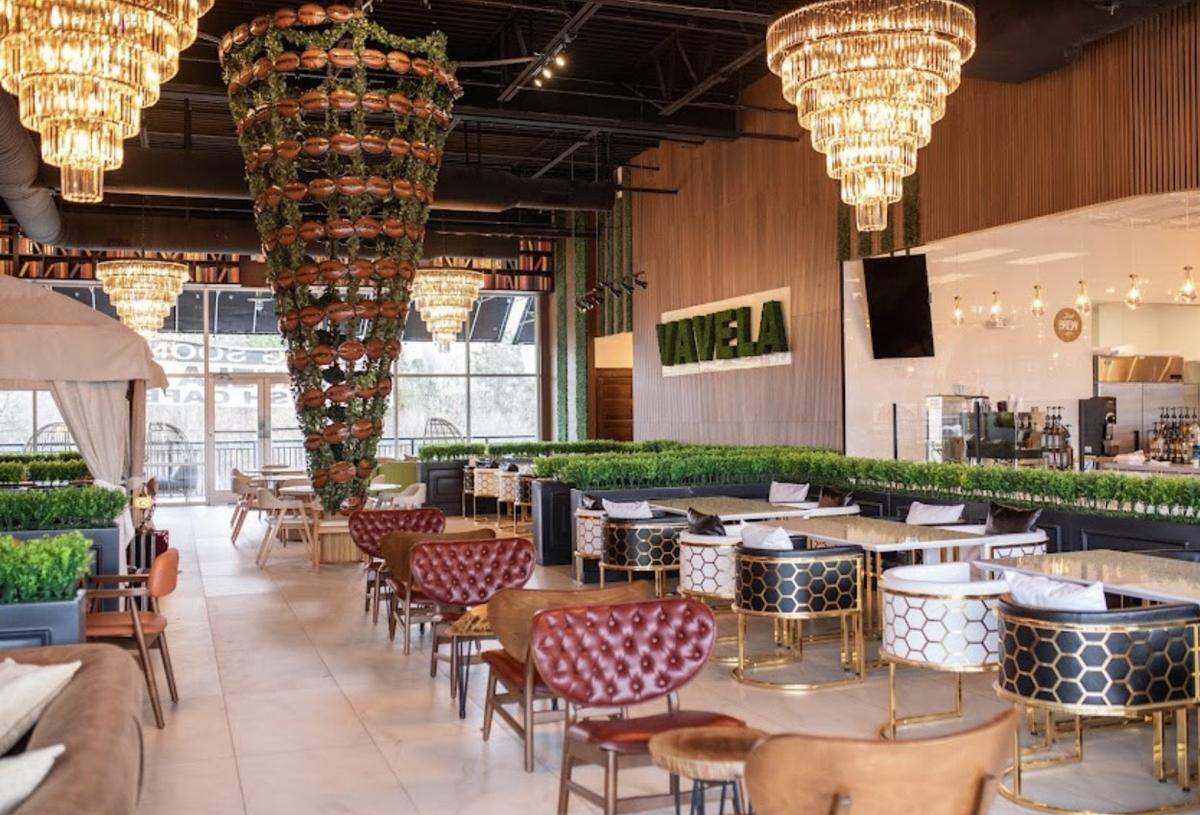 The seating area is spacious and accented with greenery at Vavela Café.