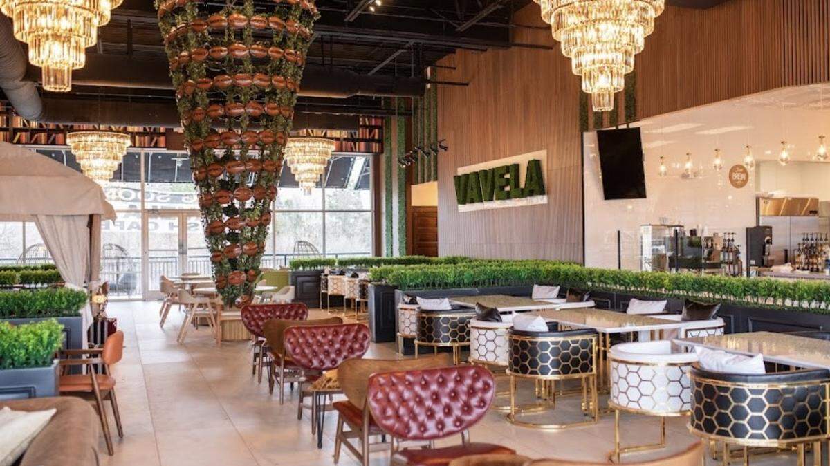 The seating area is spacious and accented with greenery at Vavela Café.
