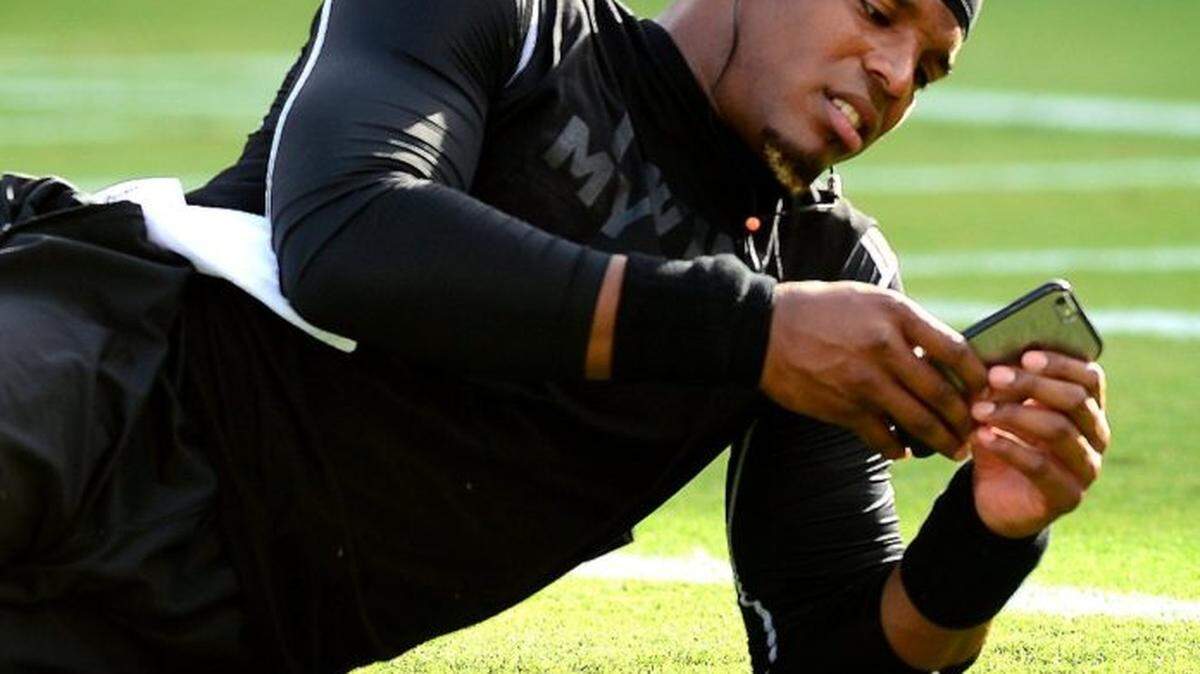 Carolina Panthers quarterback Cam Newton checks his iPhone prior to warming up for preseason action vs the Baltimore Ravens at M&T Stadium in Baltimore, MD, on Aug. 11, 2016.
