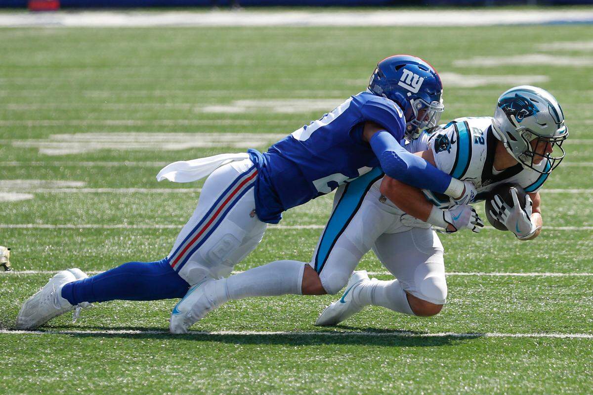 New York Giants’ Julian Love, left, tackles Carolina Panthers’ Christian McCaffrey during the first half an NFL football game, Sunday, Sept. 18, 2022, in East Rutherford, N.J. (AP Photo/Noah K. Murray)