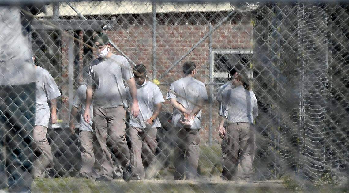 Inmates at the Neuse Correctional Institution in Goldsboro, N.C. move between buildings Sunday morning, April 19, 2020. Some are wearing masks, but incorrectly. more than 280 of 770 inmates at the Eastern North Carolina prison have tested positive for COVID-19, making it one of the hardest-hit prisons in the nation.