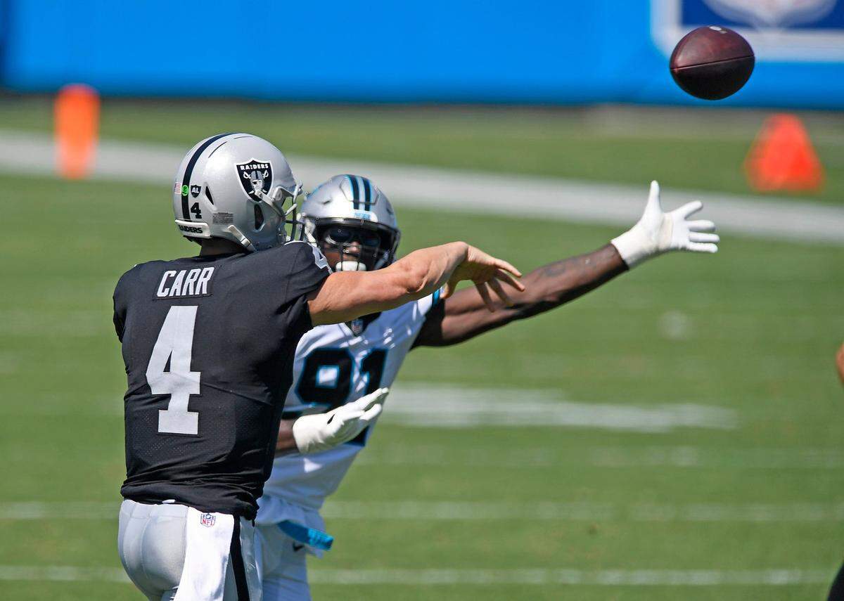 Las Vegas Raiders quarterback Derek Carr (4) gets pressured by Carolina Panthers defensive end Stephen Weatherly (91) during the first half in their opening game of the 2020 NFL season at Bank of America Stadium on Sunday, September 13, 2020.