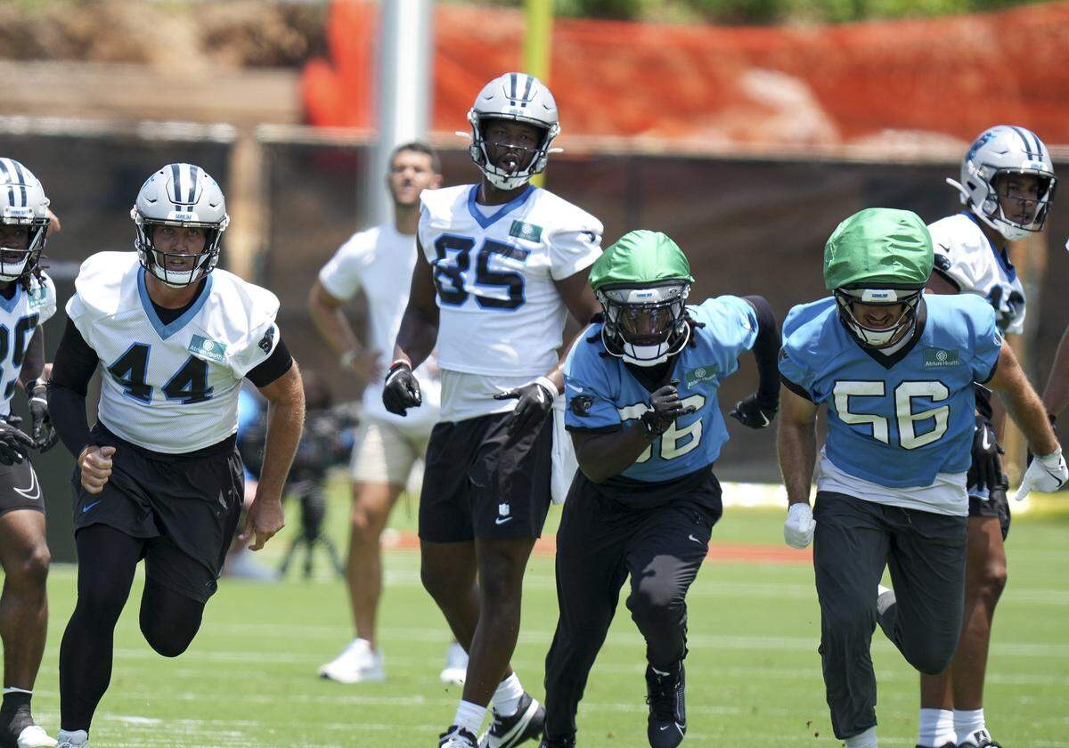 Jun 11, 2025; Charlotte, NC, USA; Carolina Panthers linebacker Nic Scourton (11), cornerback Mike Reid (35), long snapper JJ Jansen (44), tight end James Mitchell (85), safety Demani Richardson (36) and linebacker Christian Rozeboom (56) hustle to the ball during minicamp at Bank of America Stadium. Mandatory Credit: Jim Dedmon-Imagn Images