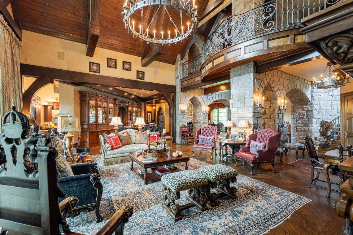 This living room area of the mansion sports a chandelier and stunning view of the surrounding mountains.
