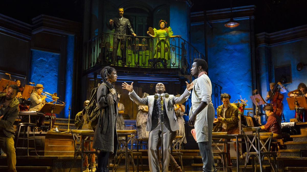 The touring cast of “Hadestown,” as Hermes (Nathan Lee Graham, center, arms wide, ) dispels some advice. The show is at Belk Theater in Charlotte through Sunday.