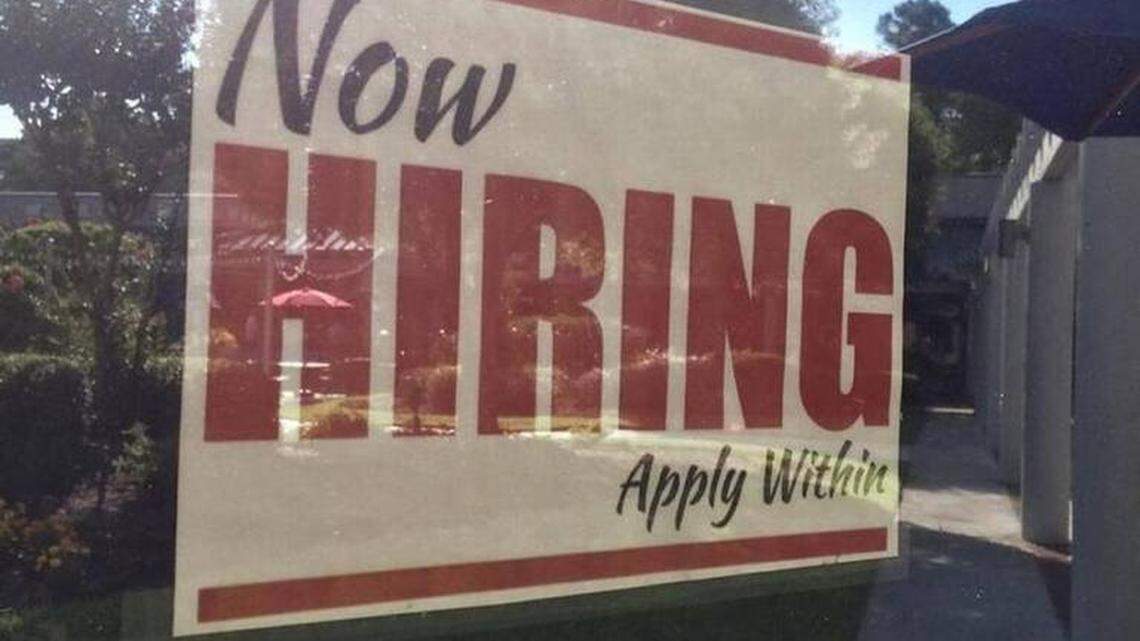 ‘Now Hiring’ sign in window.