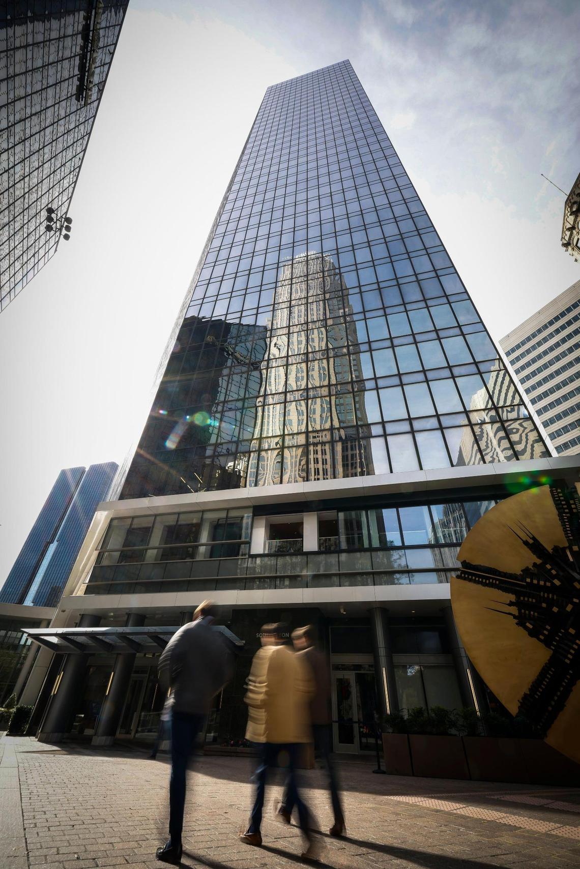 People pass One South in uptown Charlotte in November 2022. The 40-story uptown tower was built in 1974 and is currently undergoing a series of upgrades to attract new tenants.