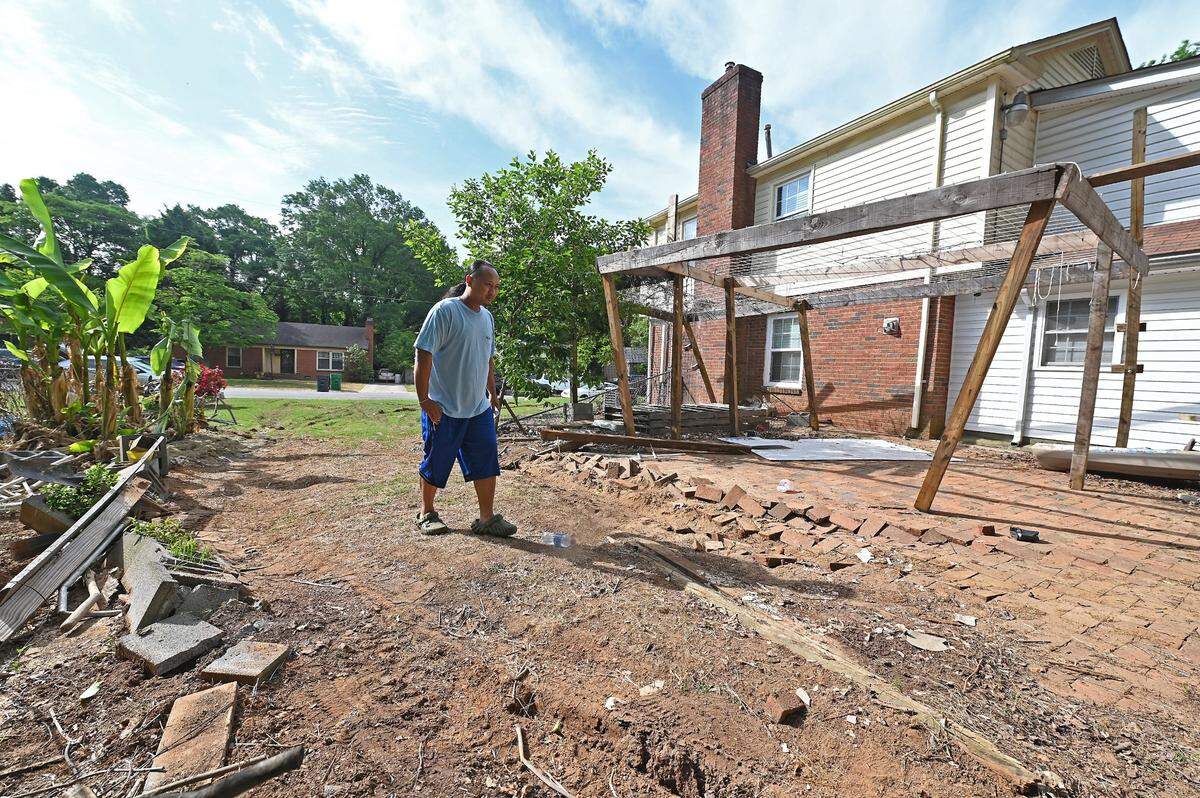 Jay Chhoeun walks through the damaged area of his yard Tuesday, April 30, 2024. Chhoeun’s home is located directly next to 5525 Galway Drive where three members of the U.S. Marshals task force were killed on Monday, April 29, 204 when they were serving a warrant in the Shannon Park area of east Charlotte. U.S. Marshals used Chhoeun’s yard as a pathway to try and gain access to the shooter at 5525 Galway Drive on Monday, April 29th. Officers also sought prospective setup points and cover from Chhoeun’s garage.