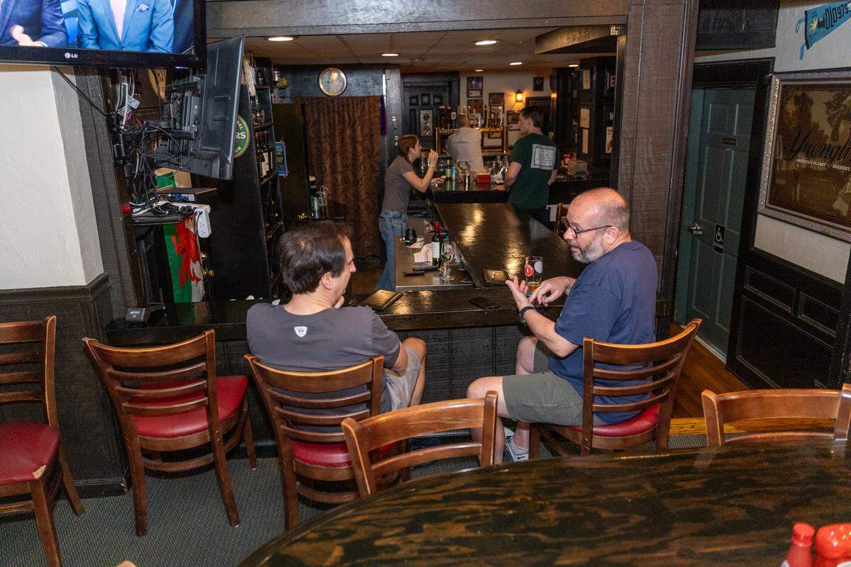 Friends meet at the end of the bar at Sir Edmond Halley’s.