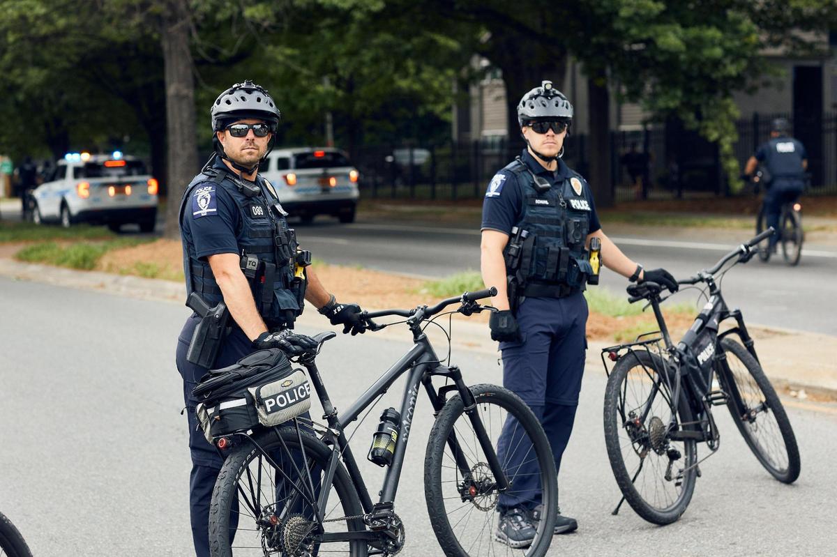 Police eye the crowd marching down Central Avenue in Charlotte Saturday.