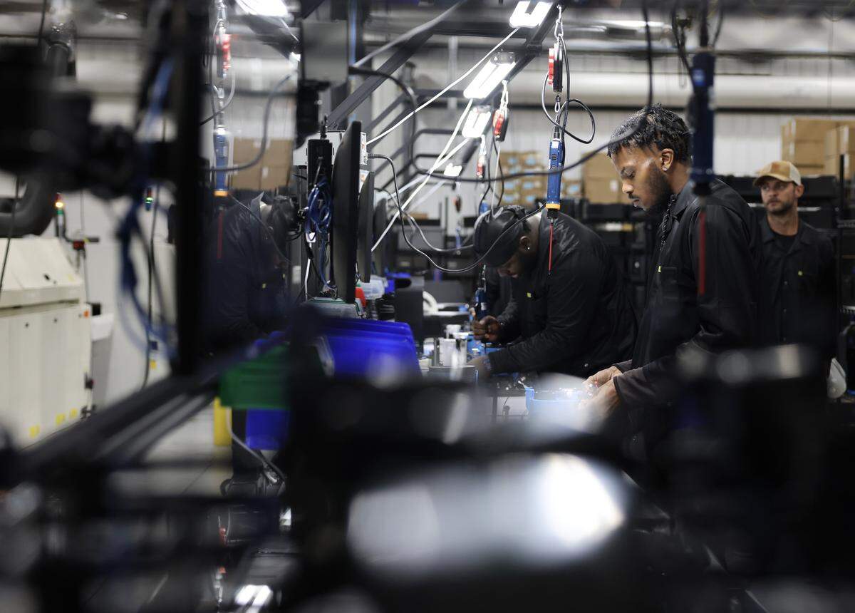 Derrick Lomax, right, and Charles Simpson work on the dock assembly line at Chilipad by Sleepme.