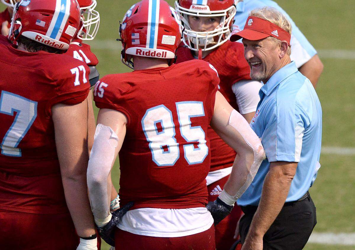 Charlotte Catholic head coach Mike Brodowicz, right, talks to his team during a timeout in the action against South Meck on Aug. 19, 2022.