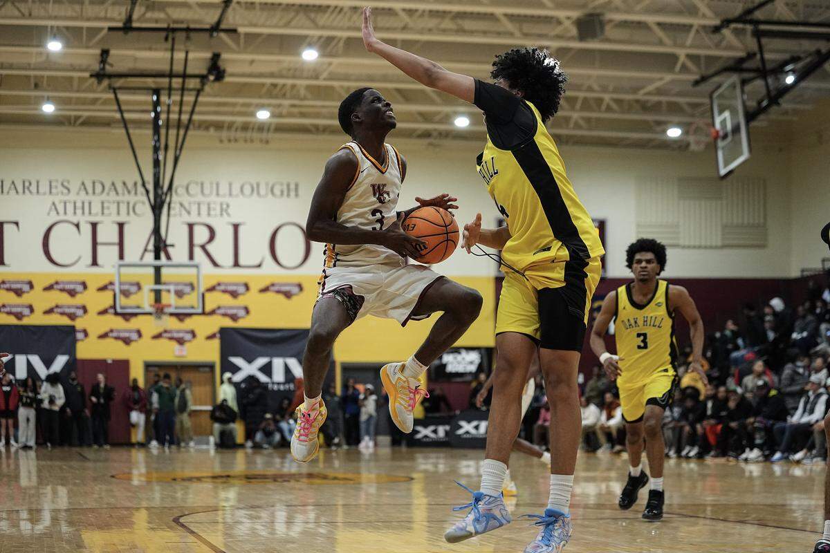 West Charlotte's Amen Ac Pressley (3) drives to the basket against Oak Hill Academy's L.J. Smith (4) during the second half of a boys varsity basketball game, Friday, Dec. 19, 2025, in Charlotte, N.C.