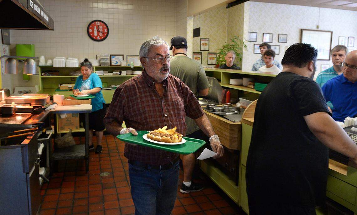 Pete Sikiotis carries an order to the counter at the Green’s Lunch on Aug. 11, 2022.