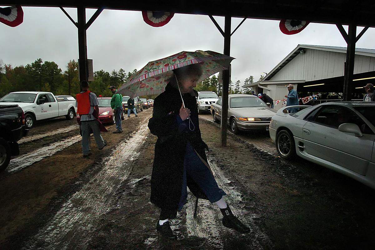 Sybil Fain carefully crosses a muddy drive as she arrives at the 78th annual Mallard Creek BBQ Thursday, Oct. 25, 2007. 