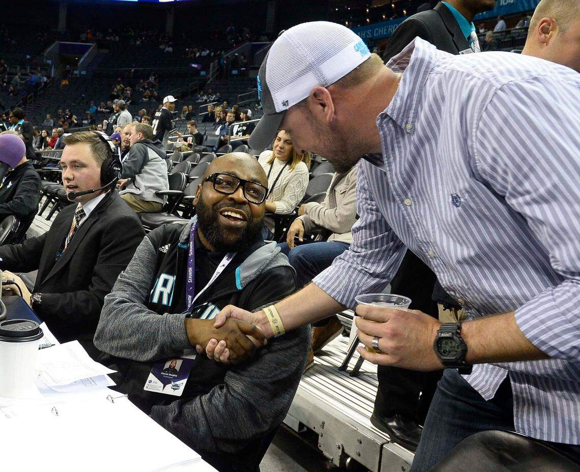 Pat Doughty, left, shakes hands with Hornets fan Jason Hames, right, during a 2016 game.
