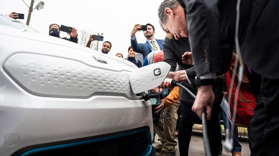 Governor Roy Cooper tests the PoleVolt EV charging station by plugging it into an electric vehicle during a visit in Washington Heights on February 24, 2022 in Charlotte.