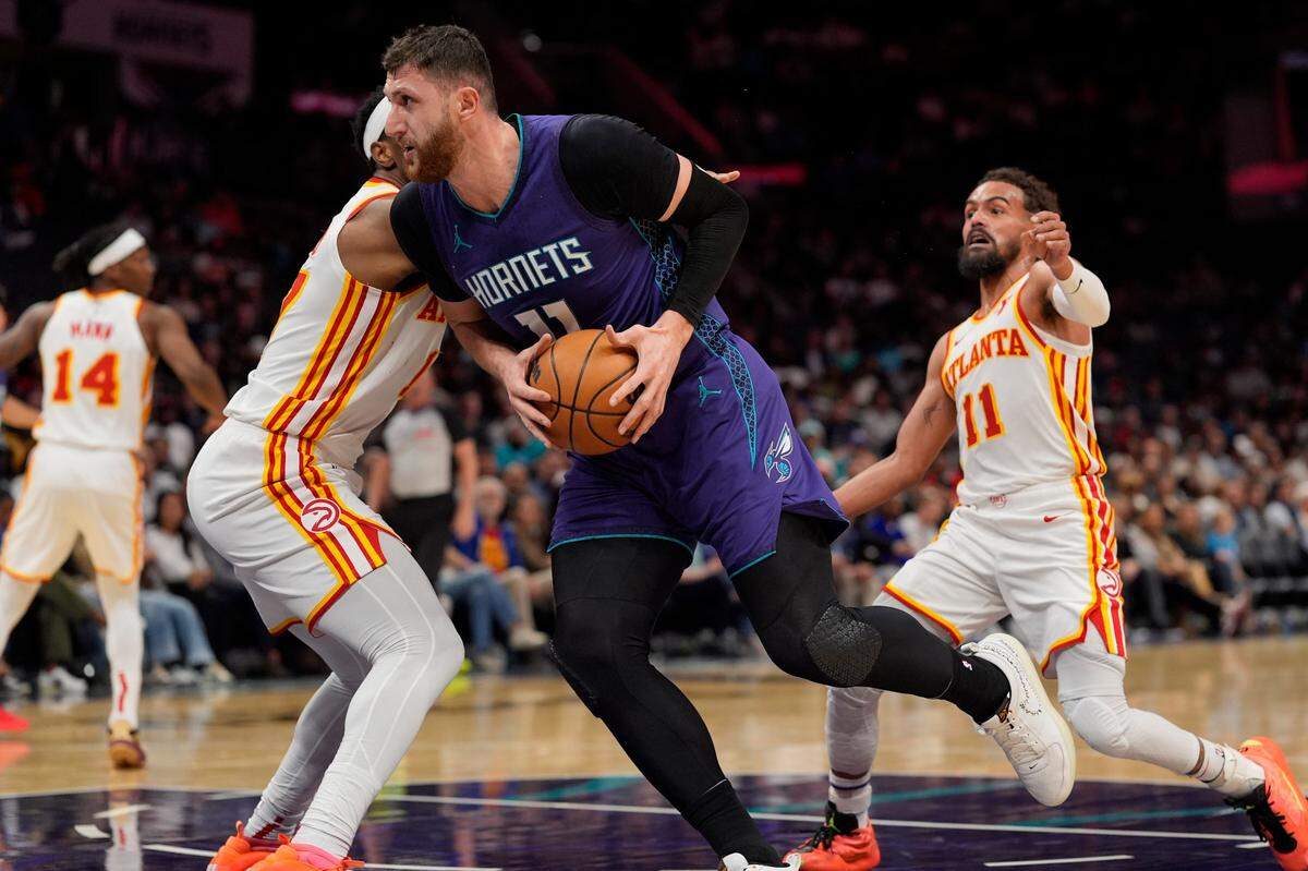Charlotte Hornets center Jusuf Nurkic (11) drives to the basket against Atlanta Hawks guard Terance Mann (14) during the second half at Spectrum Center.