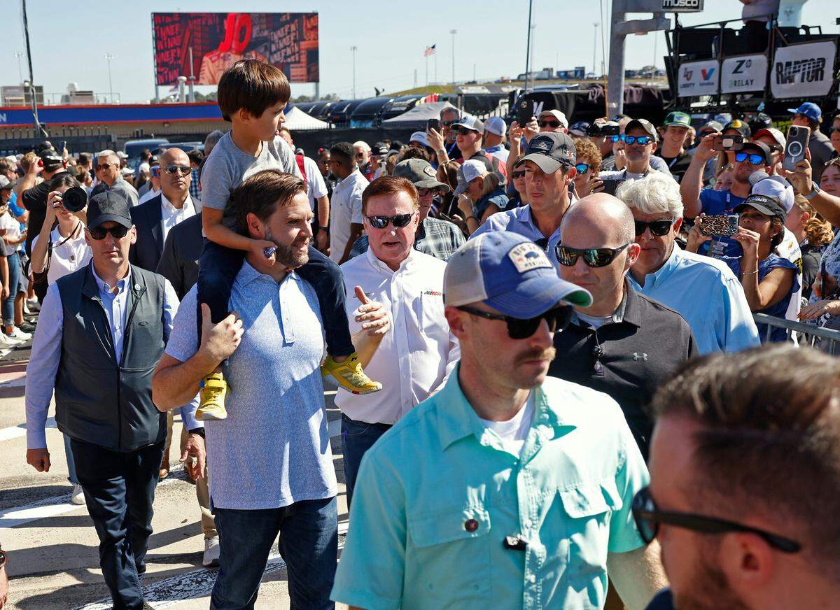 Vice Presidential Nominee Senator JD Vance, center, carries his son, Ewan, onto pit road at Charlotte Motor Speedway prior to the running of the Bank of America Roval 400 on Sunday, October 13, 2024 in Concord, NC.