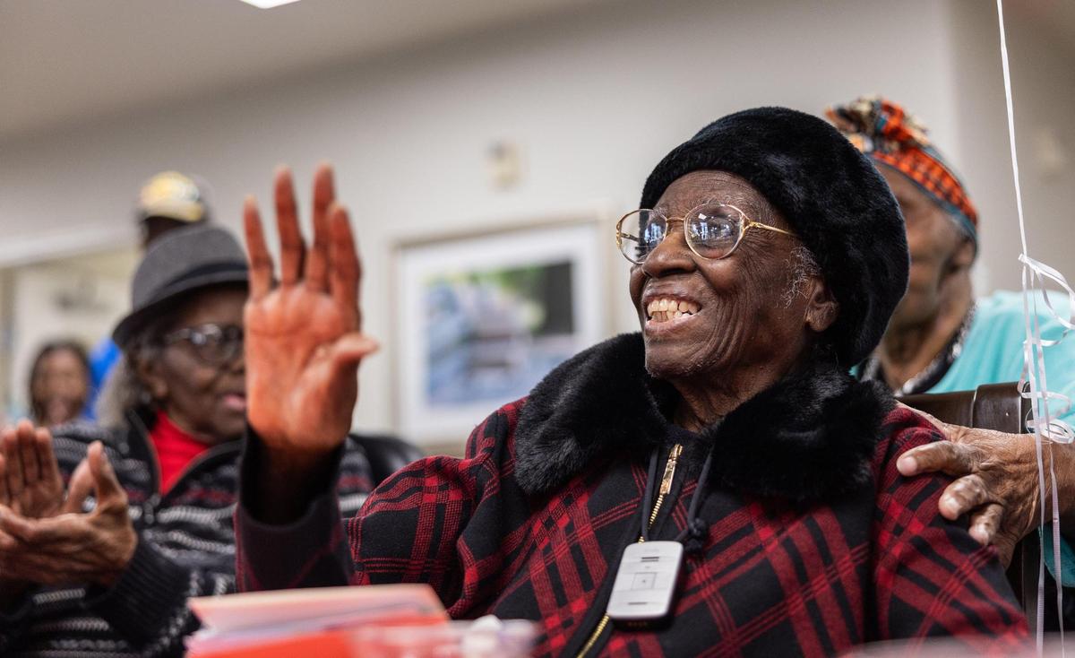 Julia Ann Teamer smiles and waves her hand back and forth as everyone sings Happy Birthday to her during her 108th birthday at her retirement community in Charlotte, N.C., on Thursday, January 16, 2025.