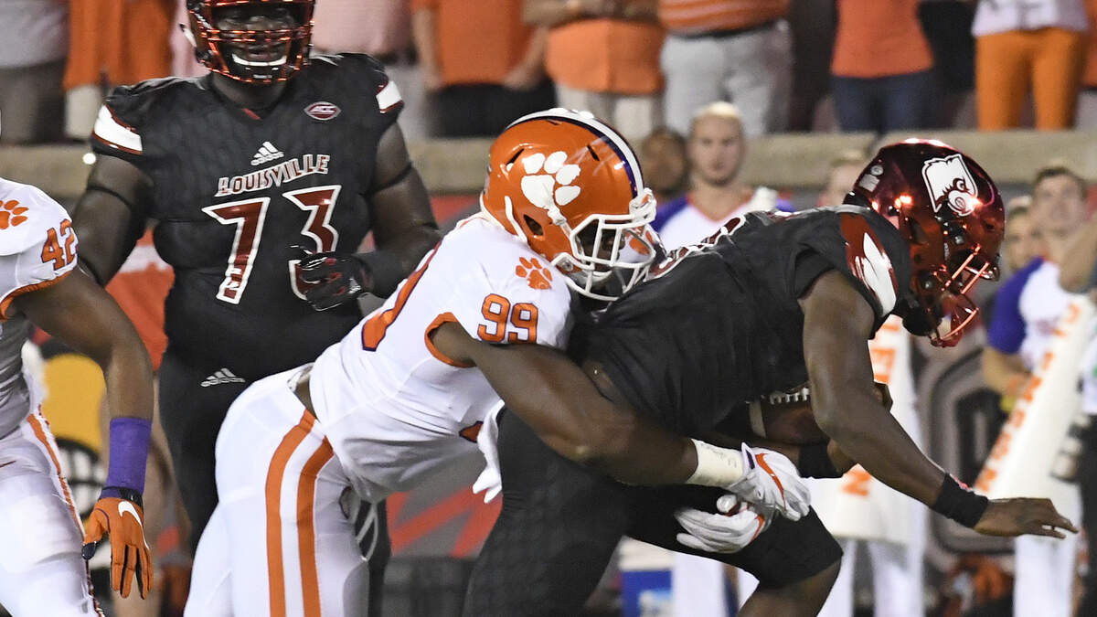Louisville's Lamar Jackson (8) is wrapped up by Clemson's Clelin Ferrell (99) during the first half of an NCAA college football game, Saturday, Sept. 16, 2017, in Louisville, Ky. (AP Photo/Timothy D. Easley)