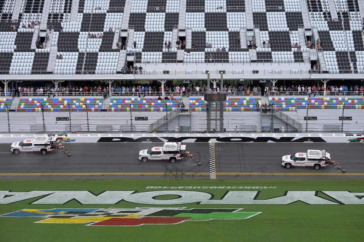 Track vehicles attempt to dry the track as it rains during a NASCAR Cup Series auto race at Daytona International Speedway, Sunday, Aug. 28, 2022, in Daytona Beach, Fla. (AP Photo/Phelan M. Ebenhack)