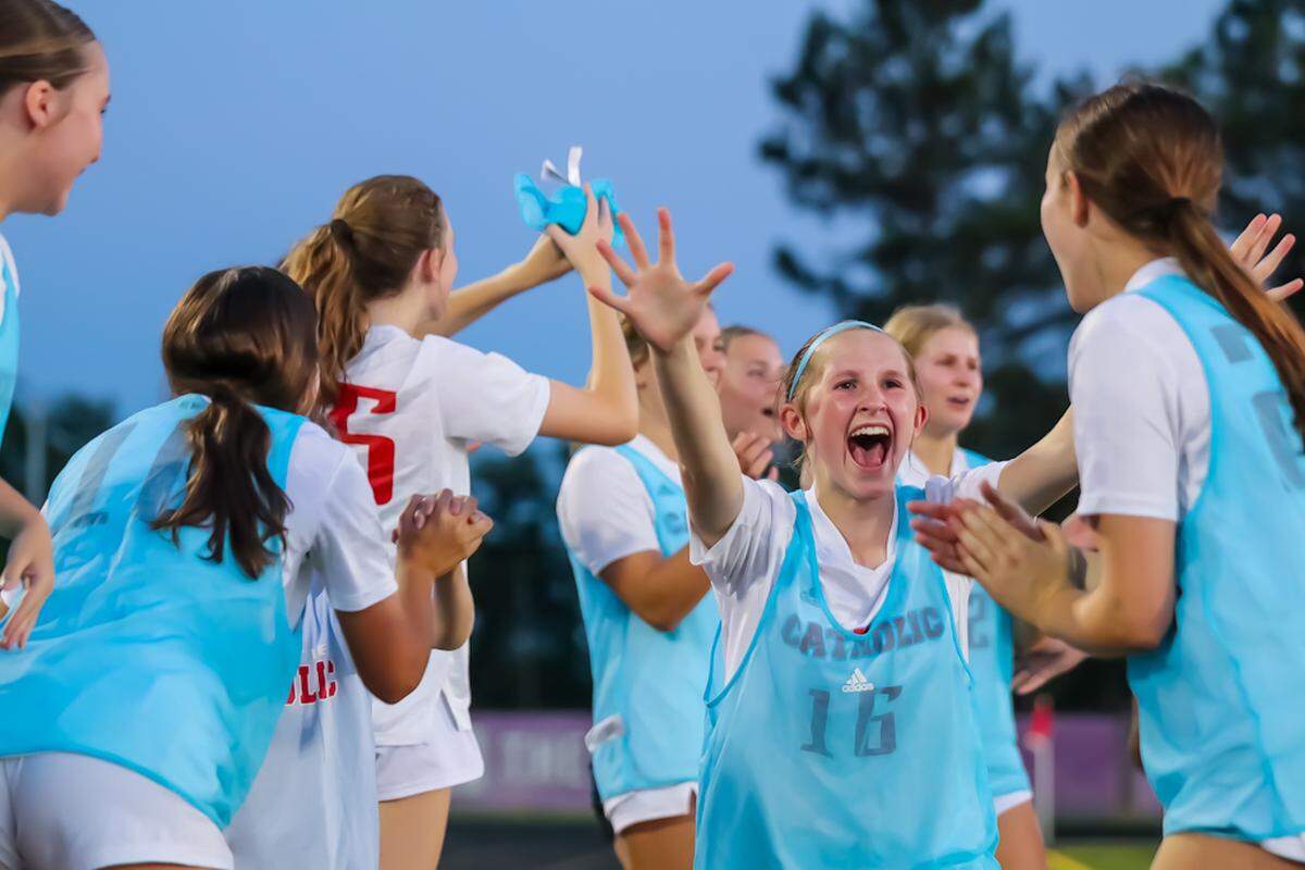 The Charlotte Catholic girls’ lacrosse team celebrates after a win at Ardrey Kell in May 2024.