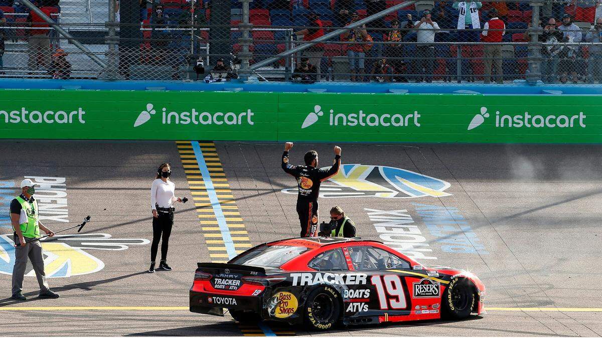 Martin Truex Jr. stands on his car as he celebrates after winning a NASCAR Cup Series auto race at Phoenix Raceway, Sunday, March 14, 2021, in Avondale, Ariz. (AP Photo/Ralph Freso)