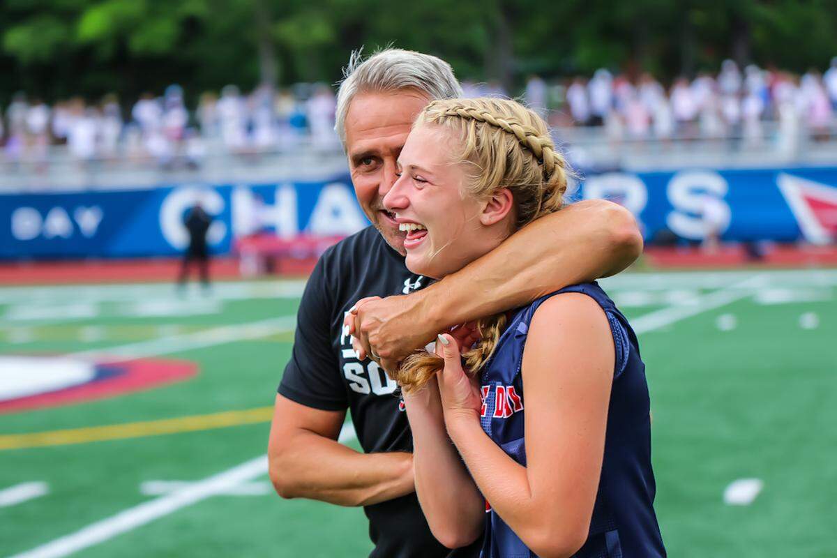 Providence day Head Coach Dam Dudley shares an emotional victory hug with his player at the NCISAA girls soccer finals at Providence Day