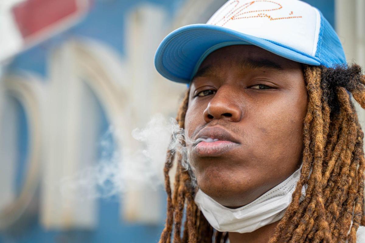 Charlotte rapper Mavi smokes a cigar outside of Midnight Diner.