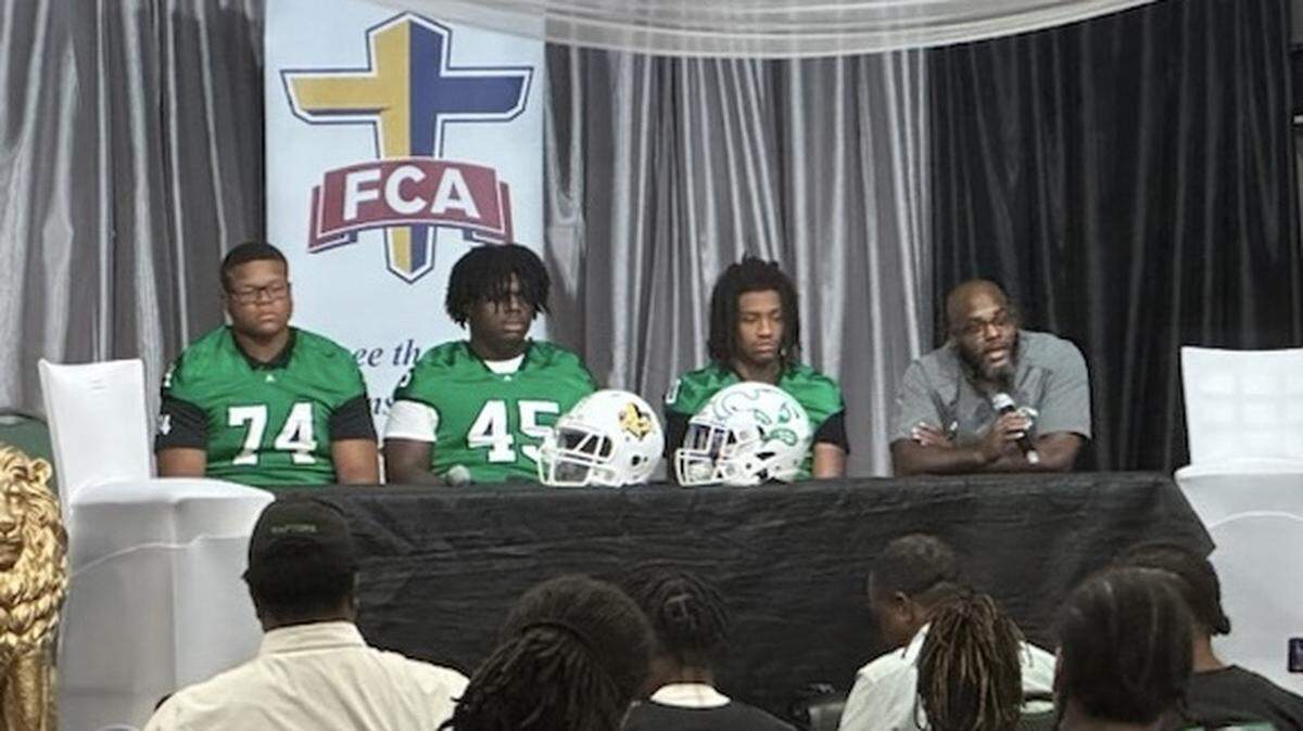 Jonathan Moore (left) sits alongside his Ashbrook football teammates.