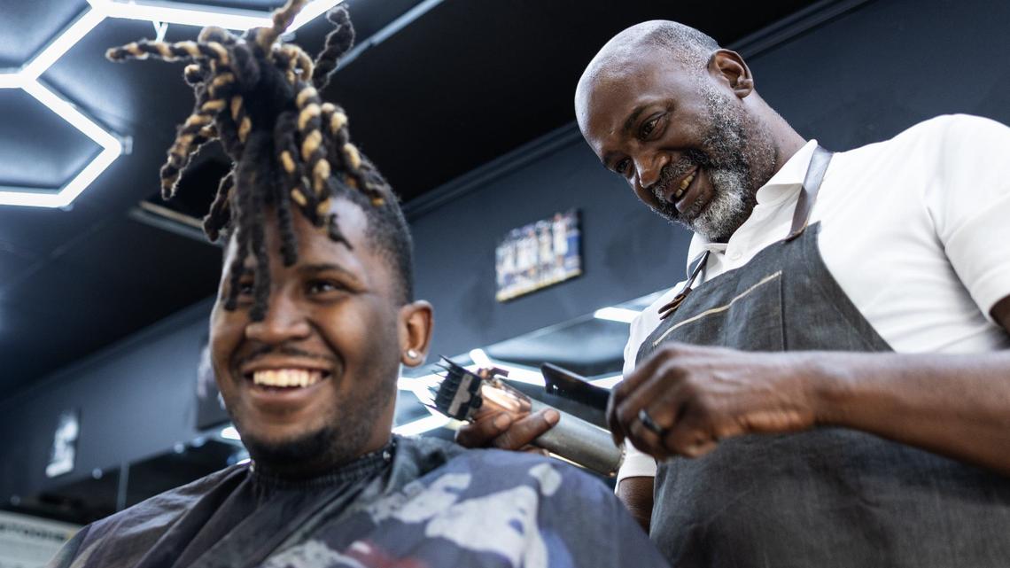 Brian Mack, right, cuts his son’s hair, B.J., at House of Hoops Barbershop in Charlotte, N.C., on Monday, July 1, 2024.