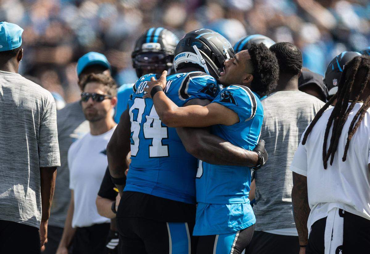 Carolina Panthers quarterback Bryce Young, right, hugs Carolina Panthers tight end Mitchell Evans at the Bank of America Stadium in Charlotte on Sunday, September 21, 2025.