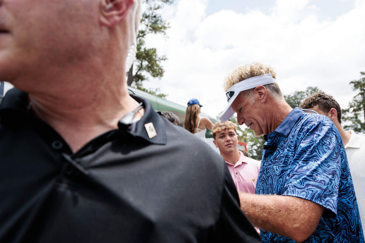 Will Ferrell — aka Lonnie Hawkins — stops to interact with fans as security escorts him through the crowd at the World Golf Hall of Fame on Thursday.