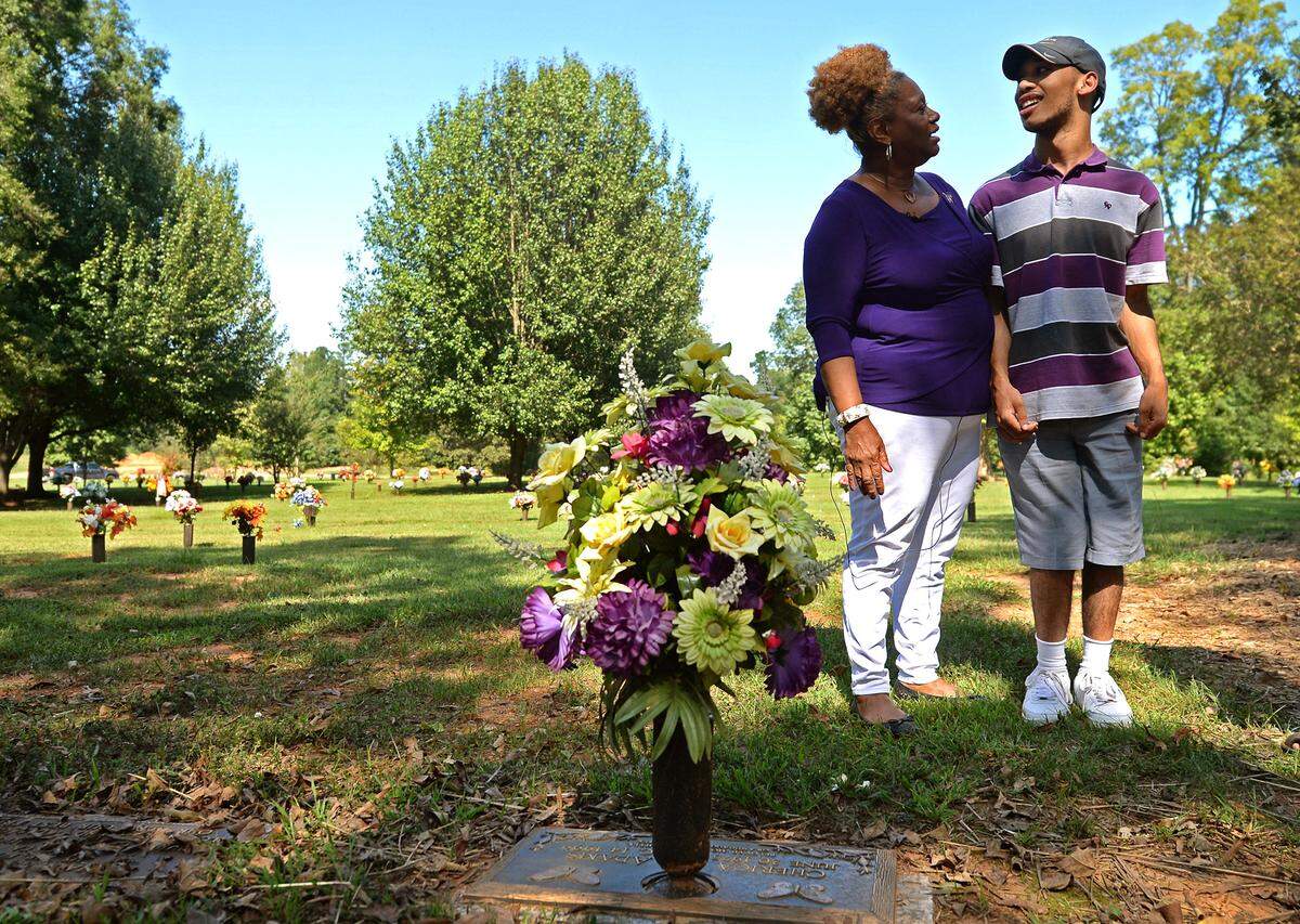 Saundra Adams (left), visiting the gravesite of her daughter Cherica Adams with her grandson Chancellor Lee in Charlotte in 2018.
