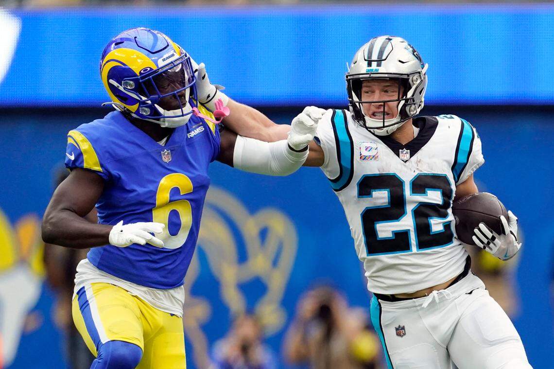 Carolina Panthers running back Christian McCaffrey (22) stiff-arms Los Angeles Rams cornerback Derion Kendrick (6) during the first half of an NFL football game Sunday, Oct. 16, 2022, in Inglewood, Calif. (AP Photo/Ashley Landis)