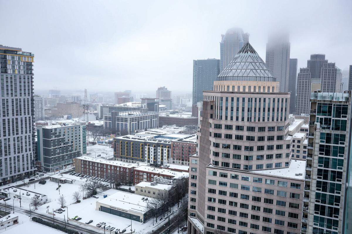 A wintry mix of snow and sleet blankets Uptown Charlotte on Sunday, January 25, 2026.